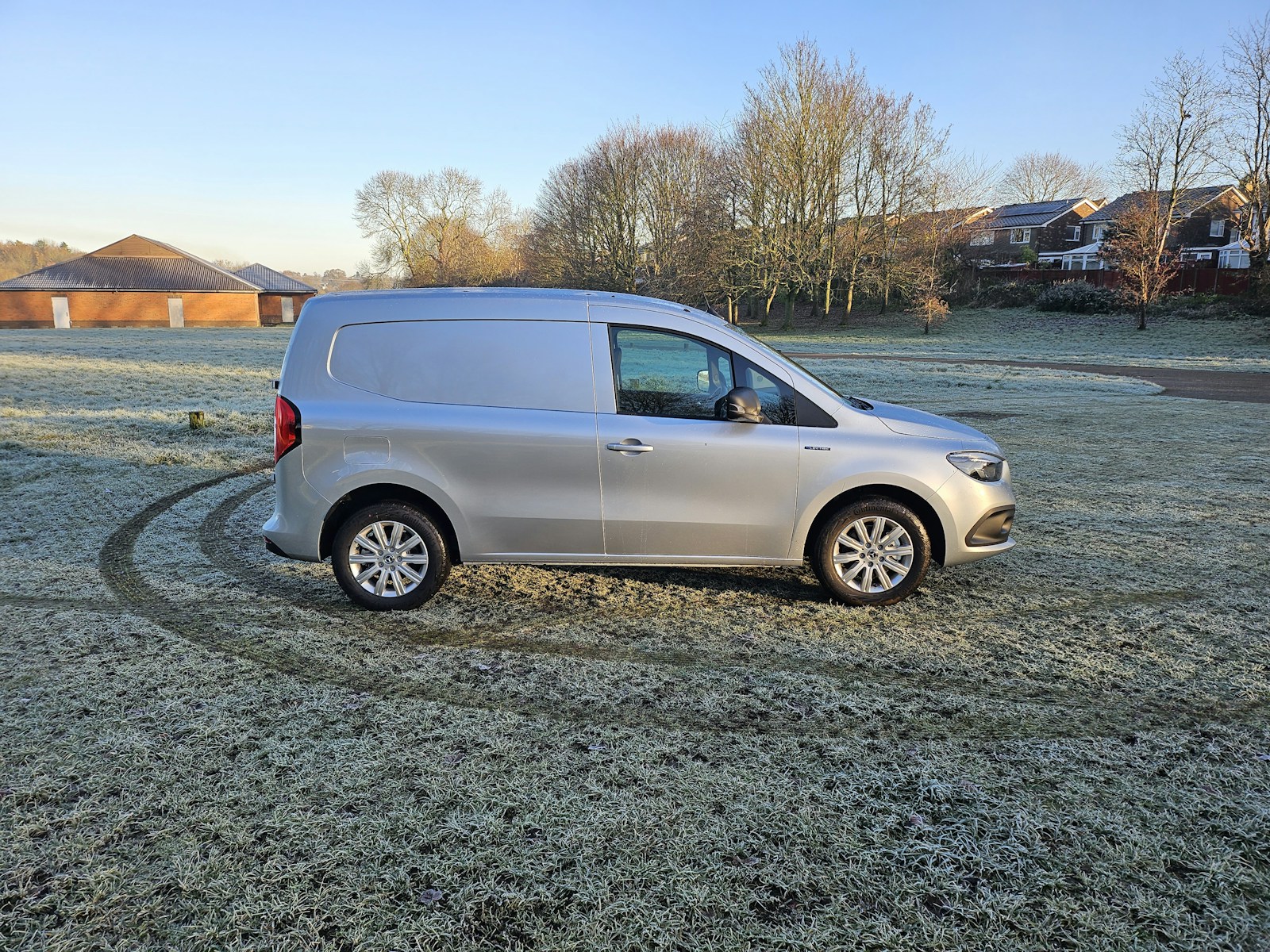 Silver panel van parked on frosty grass